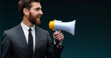 profile portrait of the friendly bearded businessman loudly speaking while holding megaphone
